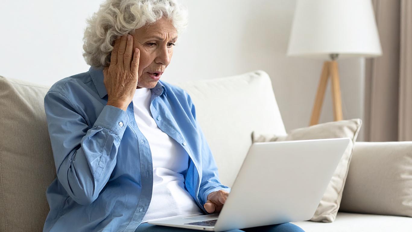 Elderly women using a laptop being scammed online.